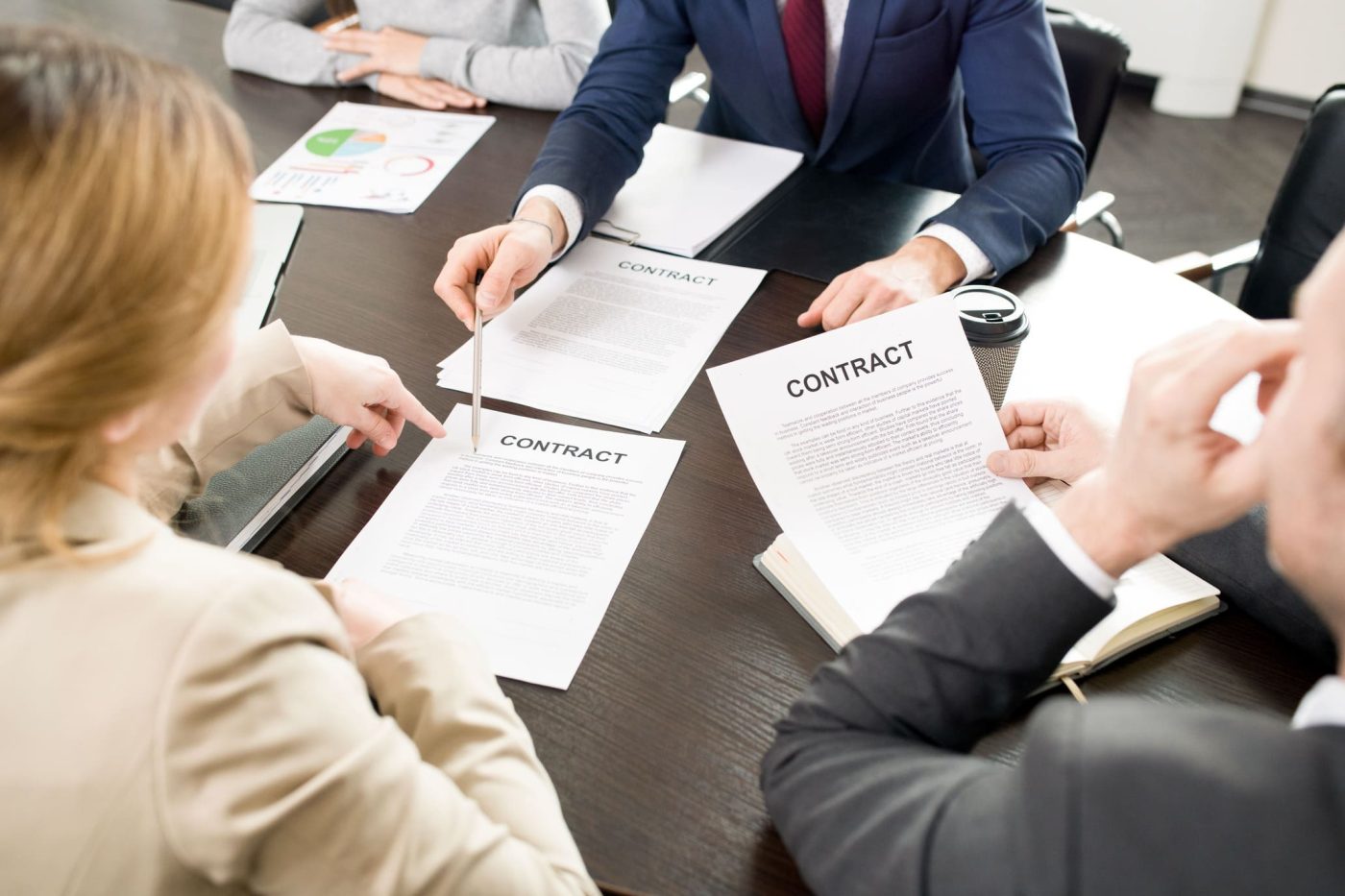 Equipo de profesionales revisando contratos de trabajo en una reunión de empresa para gestionar un ERTE por fuerza mayor.