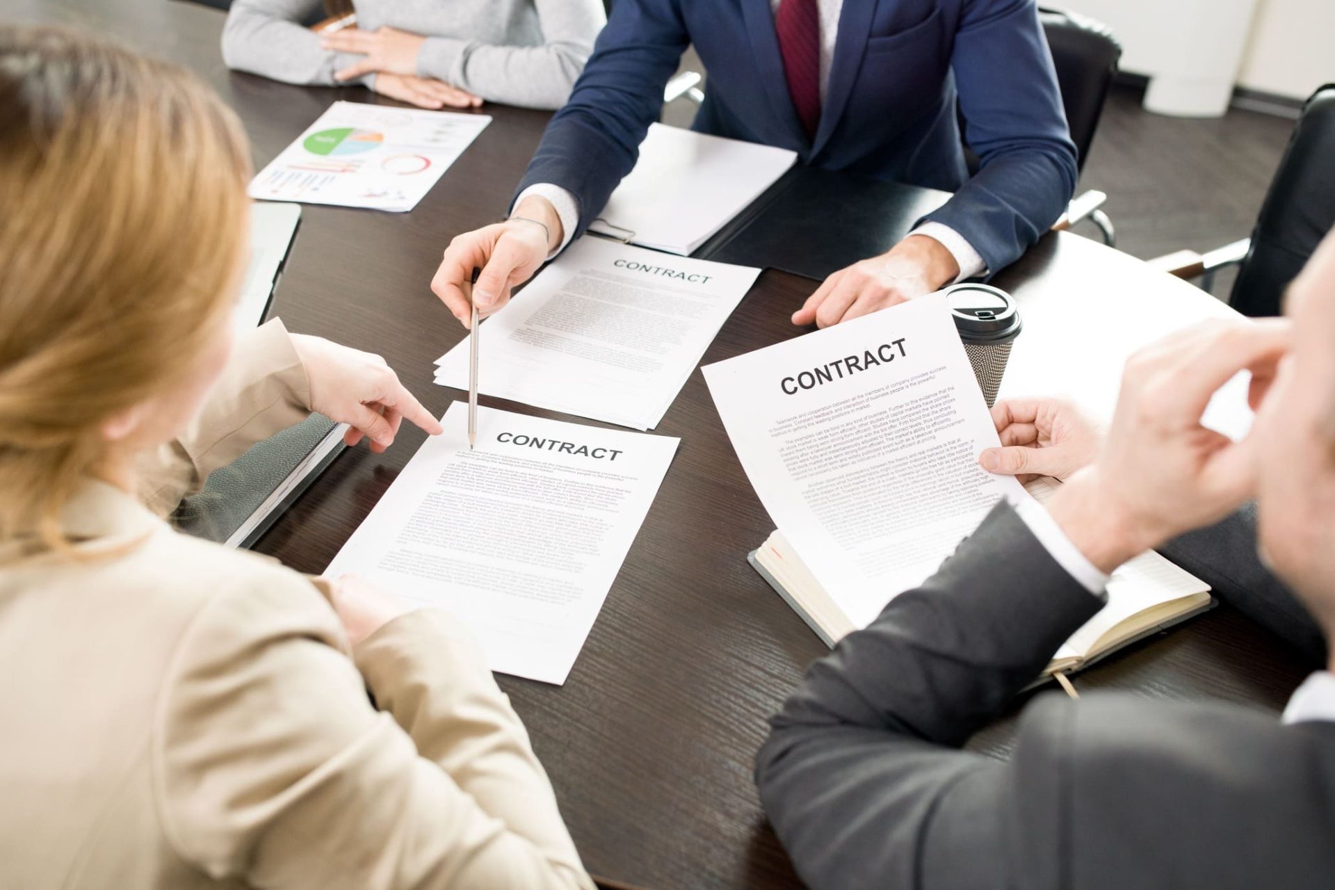 Equipo de profesionales revisando contratos de trabajo en una reunión de empresa para gestionar un ERTE por fuerza mayor.