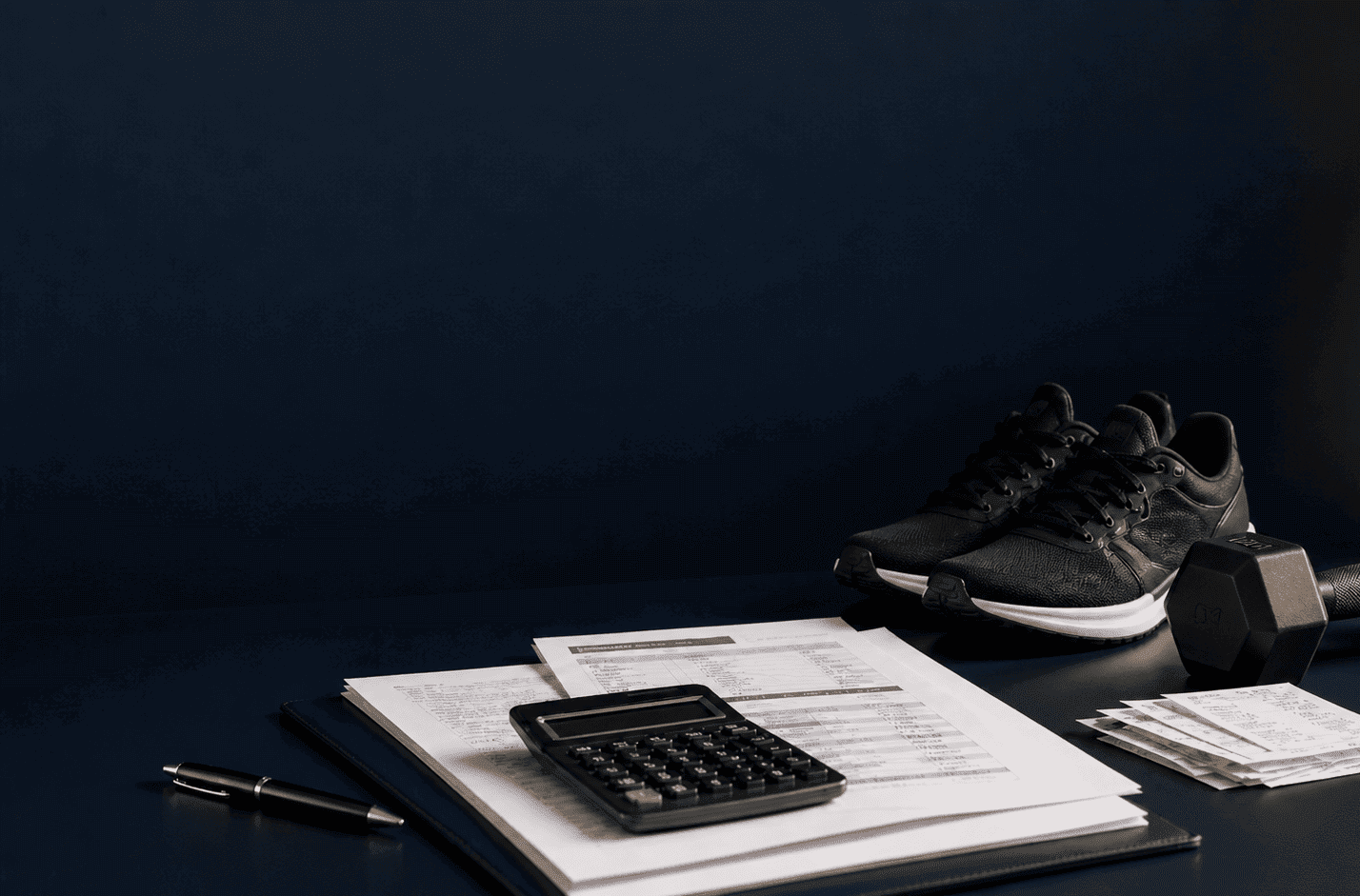 Zapatillas deportivas, mancuerna y documentos fiscales con calculadora, representando las deducciones en el IRPF por gastos de deporte y salud en la Comunitat Valenciana.