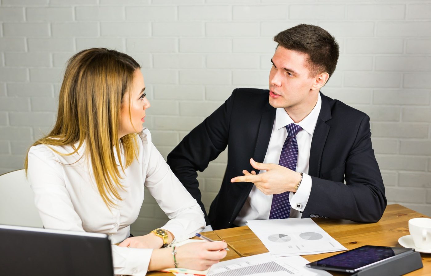 Directivo manteniendo una conversación individual con una empleada en el entorno de trabajo, representando la gestión de la ansiedad y la inseguridad en el equipo.