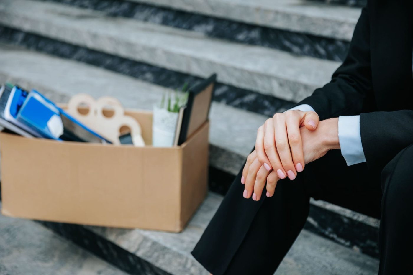 Profesional llevando caja de documentos empresa simbolizando proceso de despido laboral.
